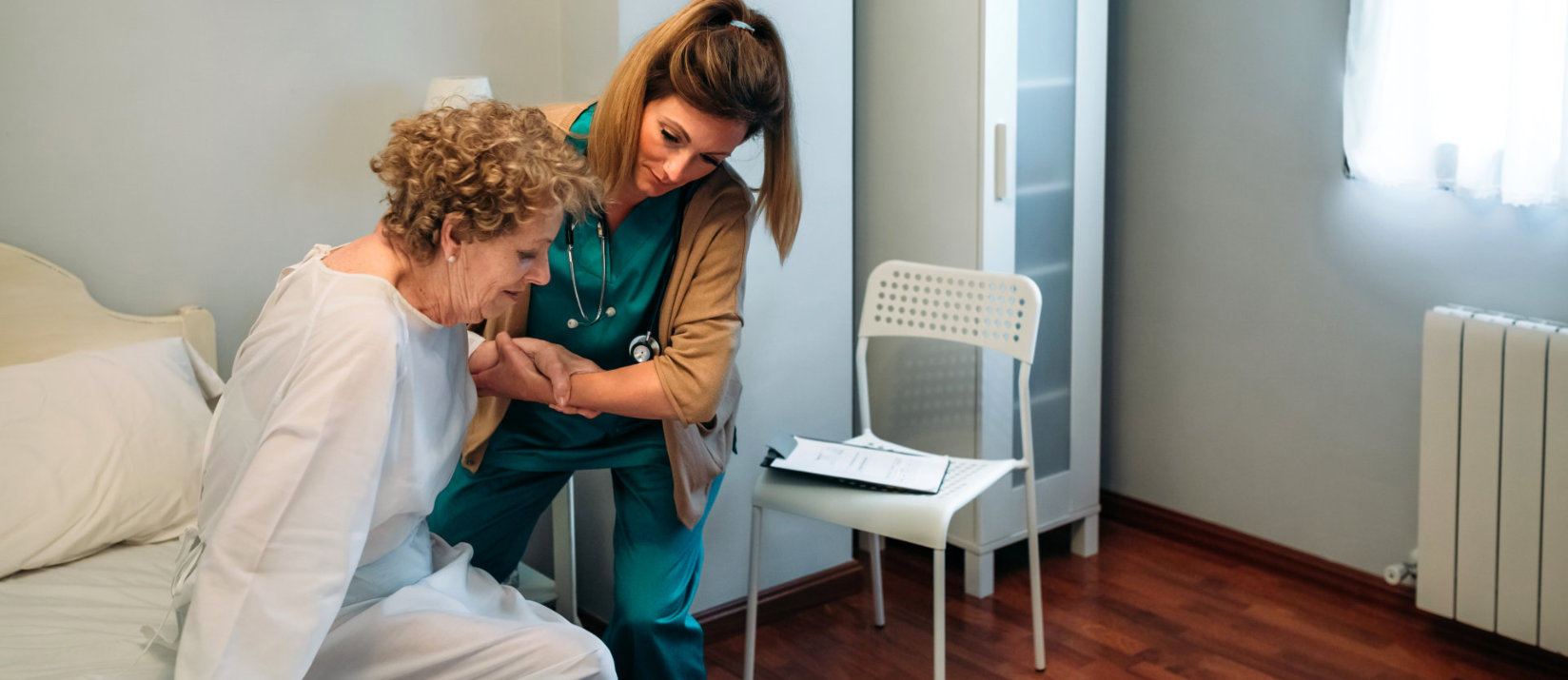 Healthcare professional with elderly patient teal scrubs