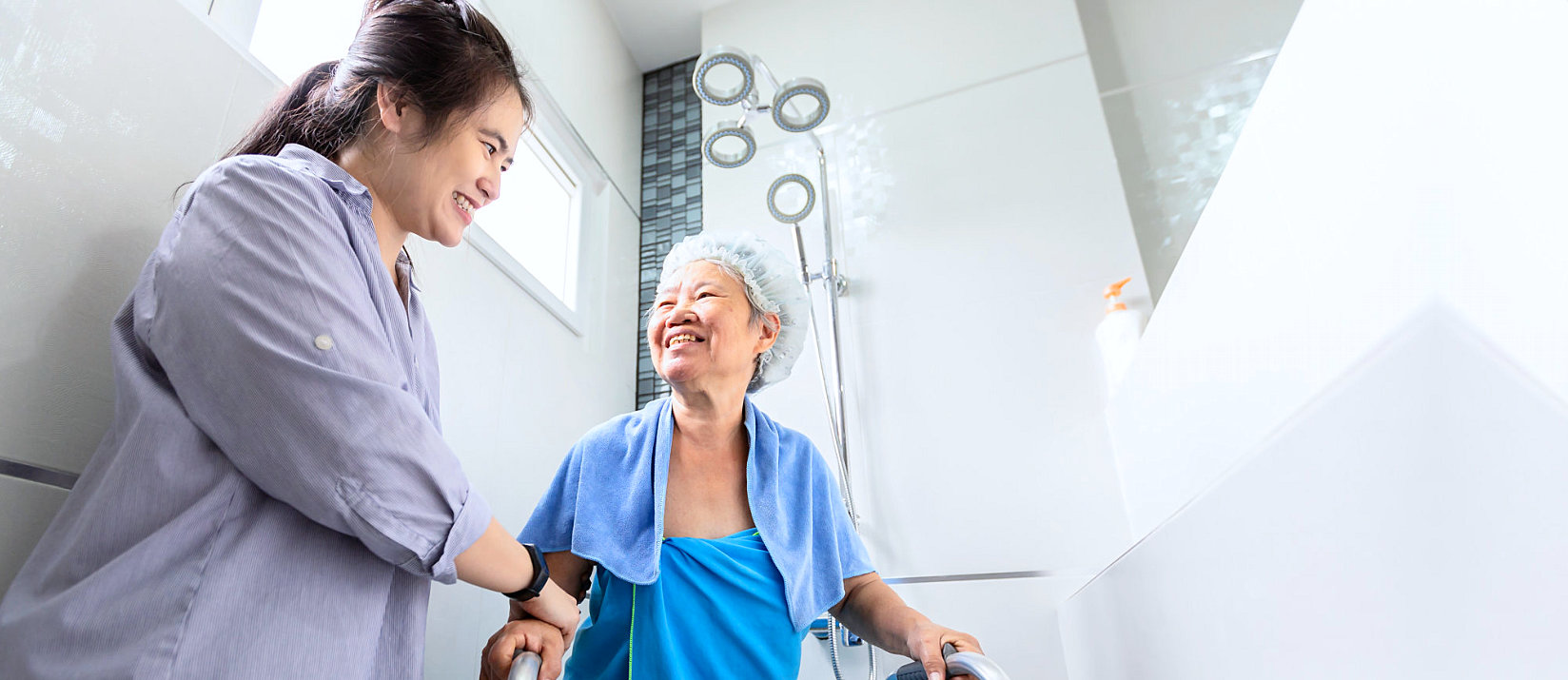 Caregiver assisting elderly woman in bathroom
